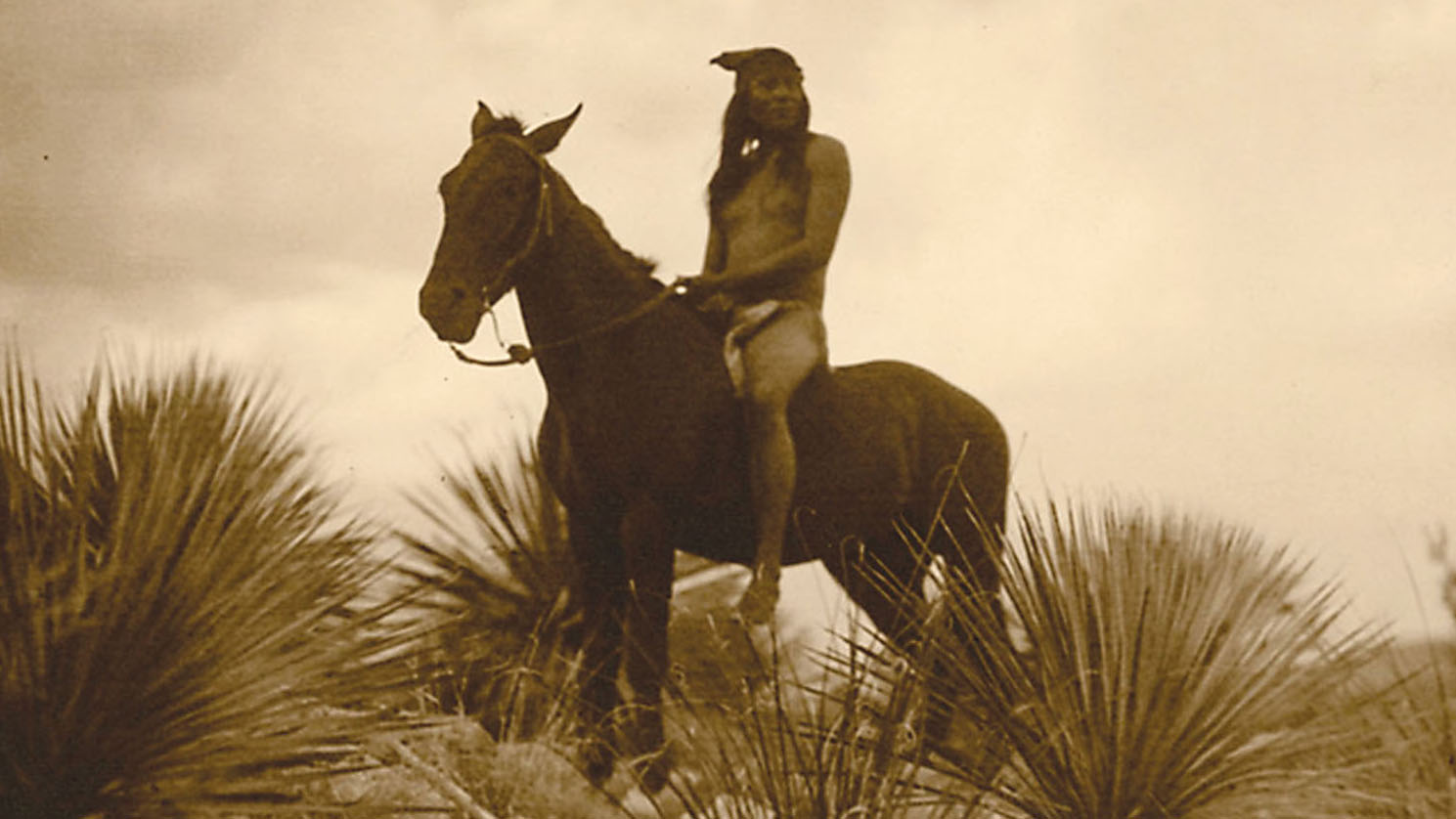 An Apache scout on horseback surveys the countryside. (Photo by Edward S. Curtis.)
