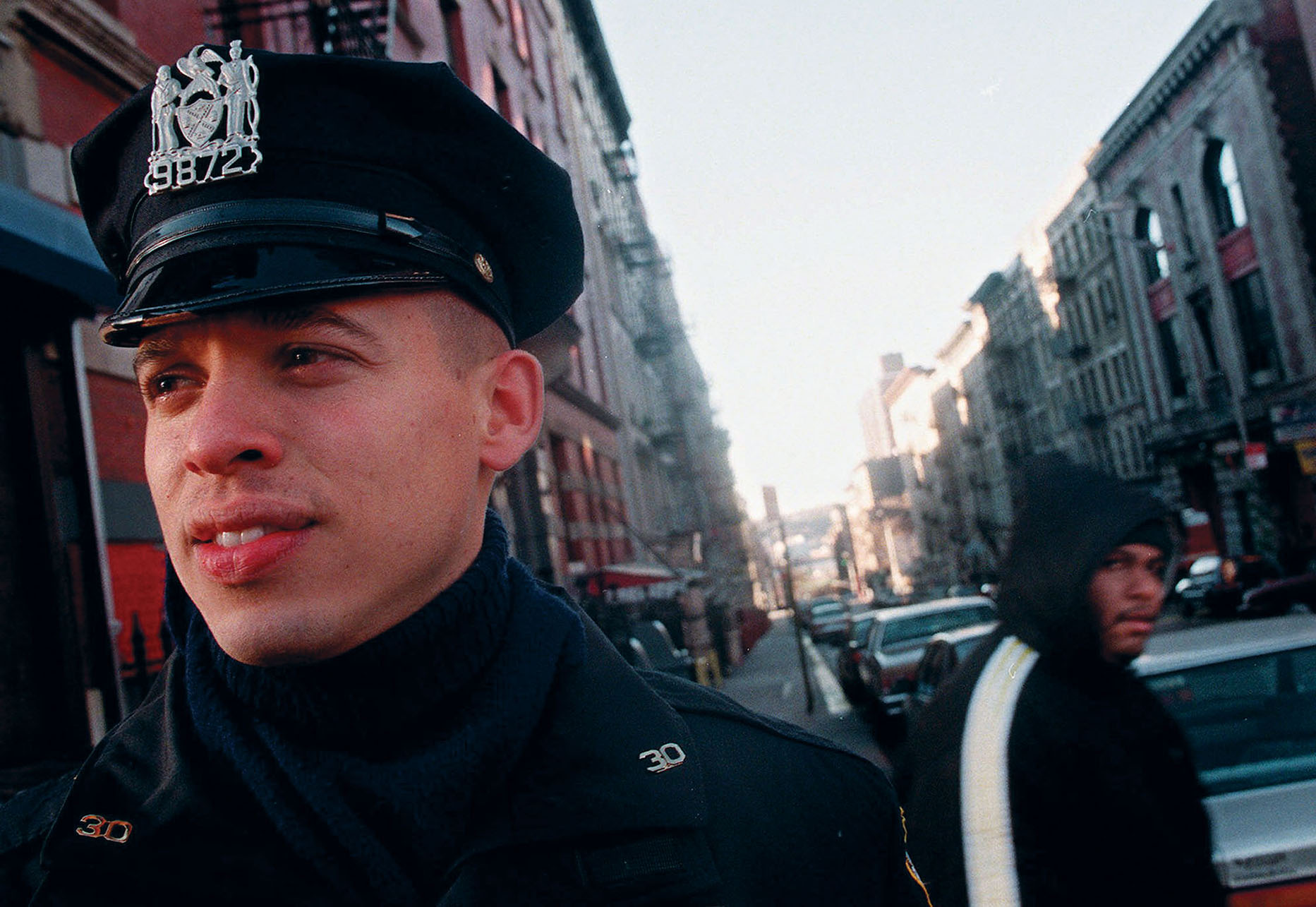 A uniformed officer patrols New York’s Washington Heights neighborhood, 1998. (Photo by Mark Lennihan, Associated Press.)