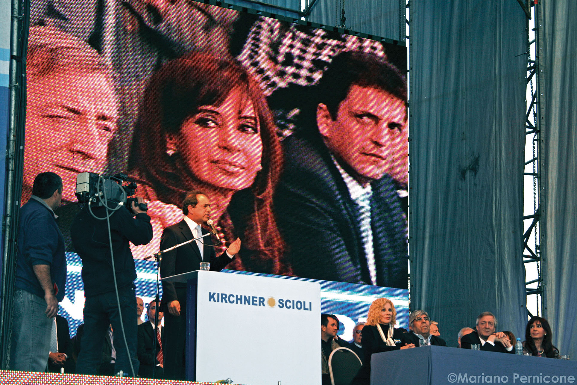 Daniel Scioli stands before a giant screen displaying Néstor Kirchner, Cristina Fernández de Kirchner, and Sergio Massa at a 2009 campaign event. (Photo by Mariano Pernicone.)