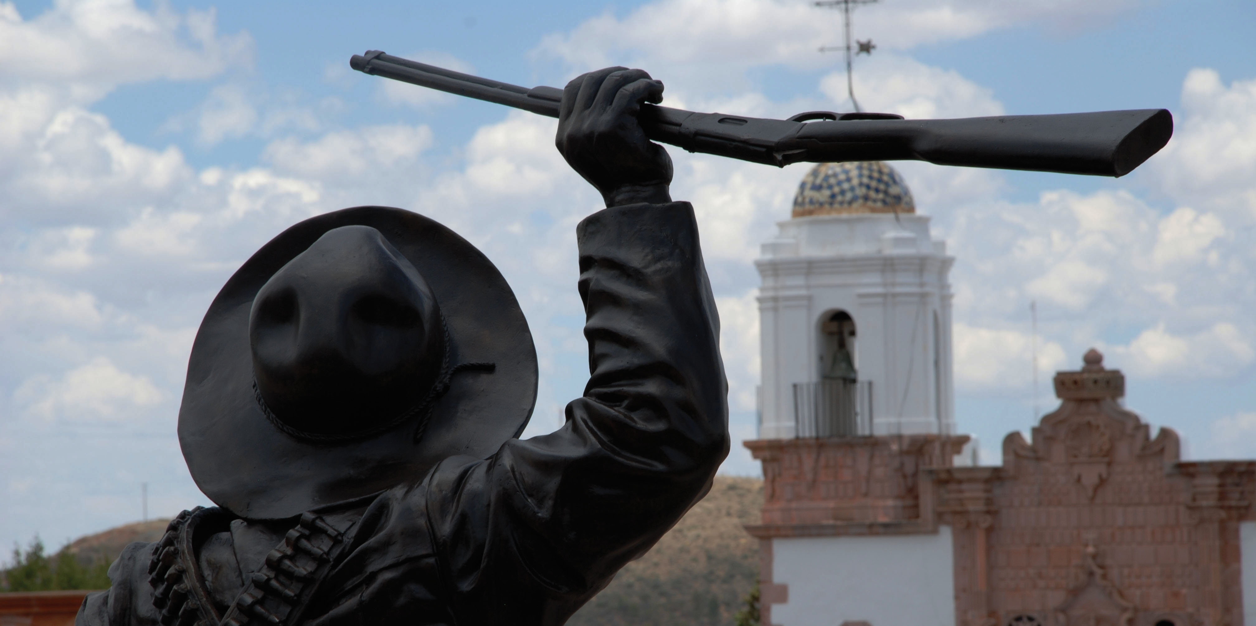 A view from behind a statue of Pancho Villa in Zacatecas, Mexico, showing him in a sombrero with a rifle in his upraised hand. (Photo courtesy of the Zacatecas Ministry of Tourism.)