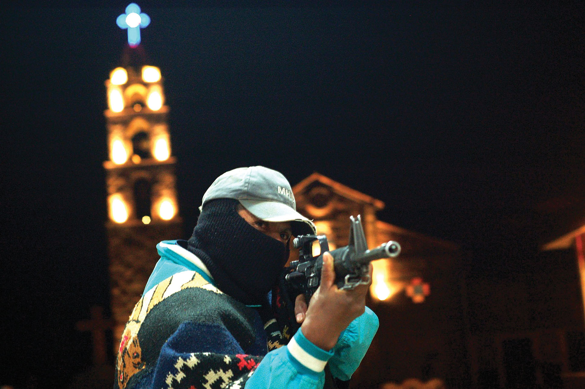 A member of the community guard of Turícuaro, Michoacán shows off by aiming his assault rifle. (Photo by Juan José Estrada Serafín.)
