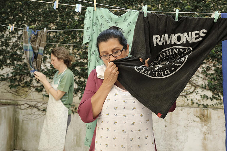 Image from "The Second Mother": two women hanging wet clothes 