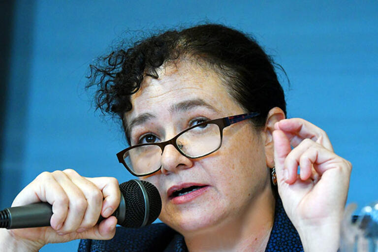 Claudia Paz y Paz talking and holding a microphone