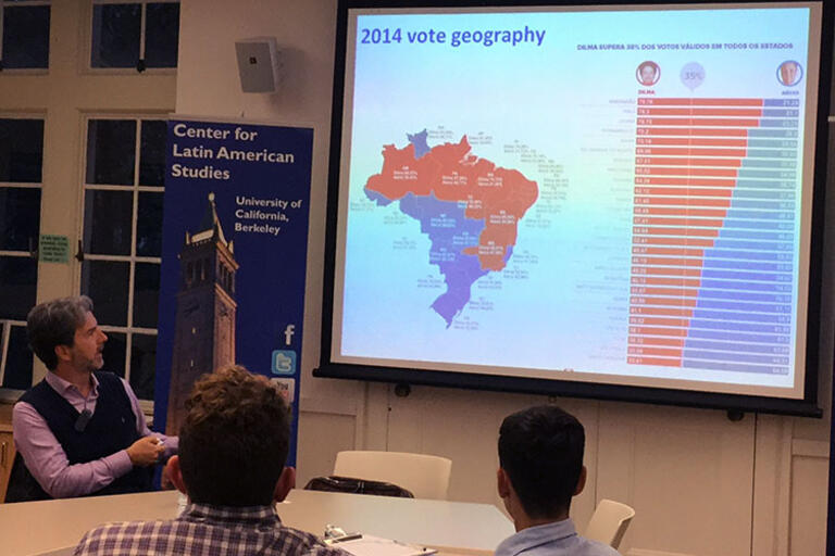 Carlos Milani speaks for CLAS, February 2017. (Photo by CLAS Staff.) Carlos Milani shows a map of the regional divide in Brazilian voting, February 2017. (Photo by CLAS Staff.) Carlos Milani seating down and showing a map of the regional divide in Brazilian voting