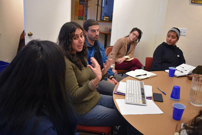 Students discussing Tinker Summer Field Research, February 2019. (Photo by Isabel Nogueira.) Five students seating at a round table talking
