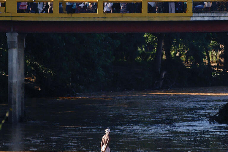 Haitians cross the Massacre River on a bridge into the Dominican Republic near Dajabón. (Photo by and © Herminio Rodríguez.)