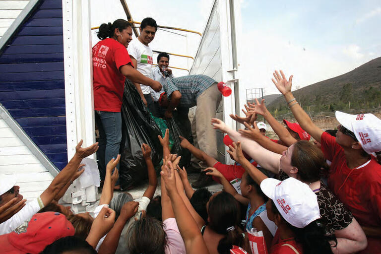 People surround a truck with hands outstretched, waiting for handouts from the Peña Nieto campaign during the 2012 election in San Luis Potosí, Mexico. (Photo by Germán Canseco/Procesofoto.)