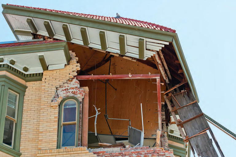 A collapsed brick corner of a building underneath its roof shows damage from the Napa earthquake of August 2014. (Photo by hitchster.)