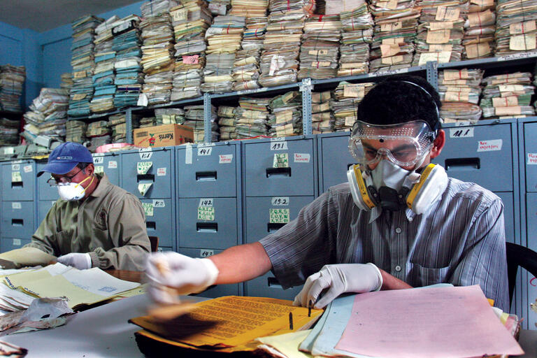 Workers at Guatemala’s Historical Archives of the National Police inspect and restore documents. ((Photo by Rodrigo ABD/Associated Press.))