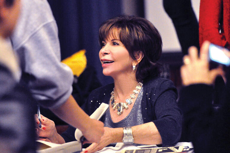 Isabel Allende looks up at an audience member as she signs copies of "Maya's Notebook" at UC Berkeley. (Photo by Peg Skorpinski.)