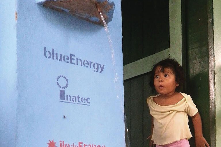 A young girl watches a water filtration unit in action. (Photo courtesy of blueEnergy.) A young girl watches a water filtration unit in action. (Photo courtesy of blueEnergy.)