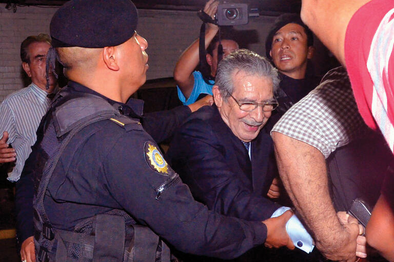 Former dictator Efraín Rios Montt is led away following his conviction. (Photo by José Anotnio Castro.) Former dictator Efraín Rios Montt is led away in handcuffs by Guatemalan police following his conviction. (Photo by José Anotnio Castro.)