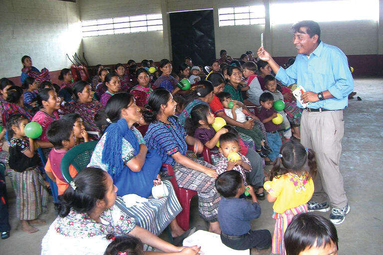 A local community health promoter working in Guatemala. (Photo courtesy of Paul Wise.) A local community health promoter educates a crowd in Guatemala. (Photo courtesy of Paul Wise.)