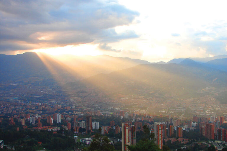 Beams of light illuminate the city as the sun breaks through the clouds over Medellín, Colombia. (Photo by Iván Jere Jota.)