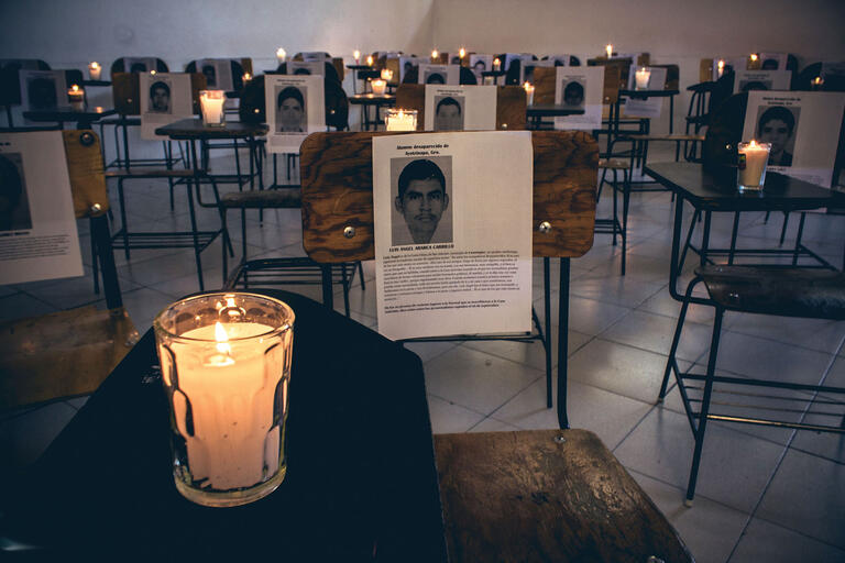 Candles sit on student desks in a memorial to the disappeared students in Ayotzinapa, 2015. (Photo by Uriel López.)