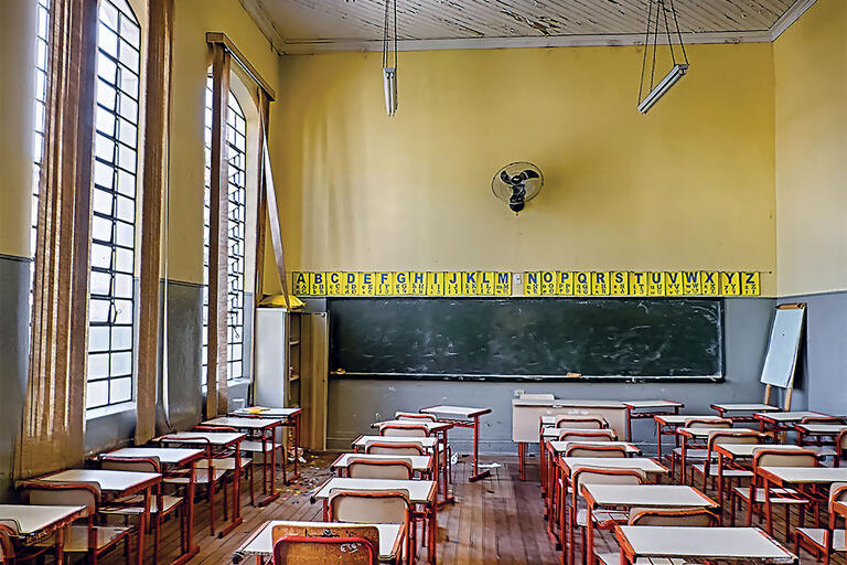Desks and a blackboard in a somewhat dilapidated Brazilian classroom. (Photo by Carlos Ramalhete.)