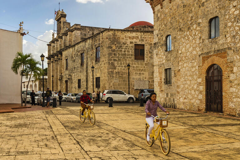 Santo Domingo Two people ride bikes through Santo Domingo