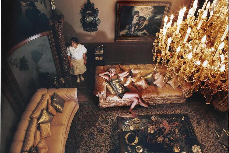 Rich and Famous. (Photo by Daniela Rosell.) A woman lies on a couch in an opulent room while a maid stands by
