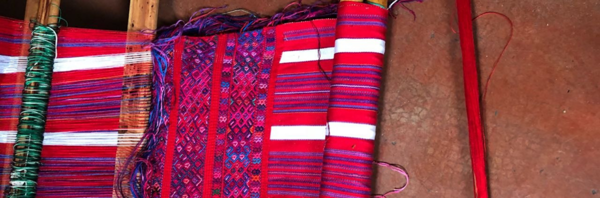 Red, purple, white weaving on a loom