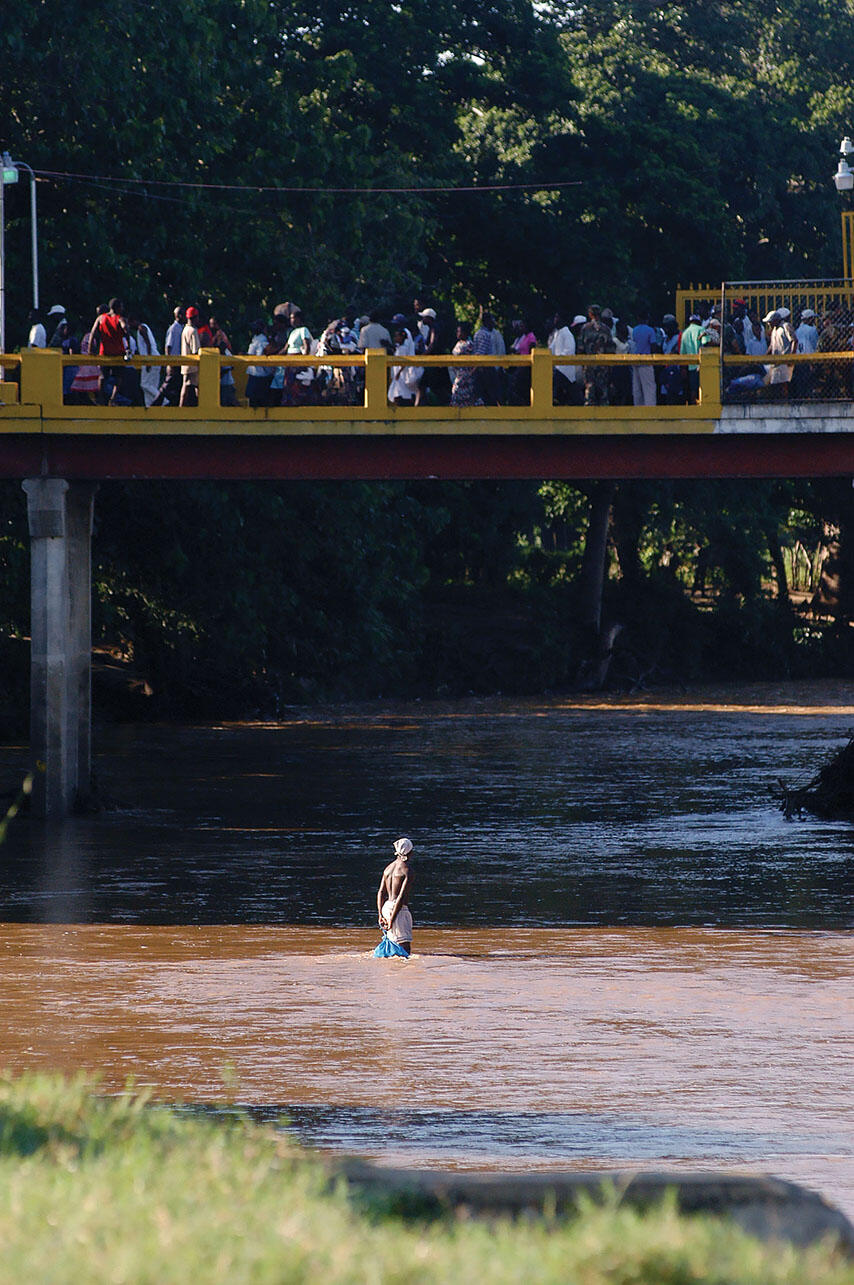 Haitians cross the Massacre River on a bridge into the Dominican Republic near Dajabón. (Photo by and © Herminio Rodríguez.)