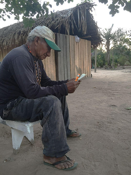 Lídio Karo looking over his notes of stories and chants. (Photo courtesy of Ailén Vega.)