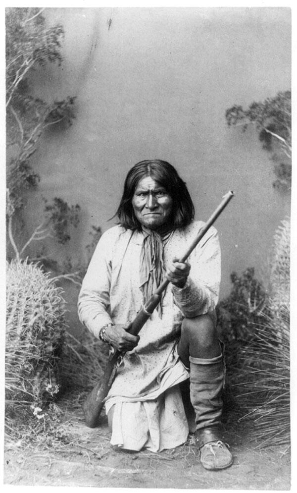 The Apache leader Geronimo, kneeling with a rifle, 1886. (Photo by A.F. Randall, Wilcox, A.T.)