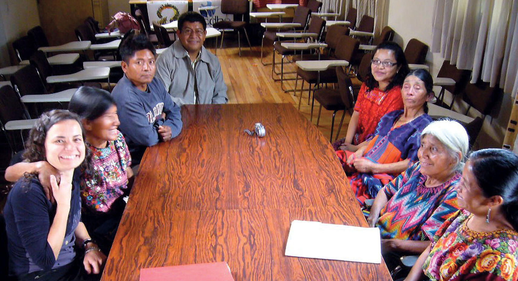 Almudena Bernabeu seated at a table with the Guatemalan witnesses who traveled to Spain to testify. (Photo courtesy of Pamela Yates.)