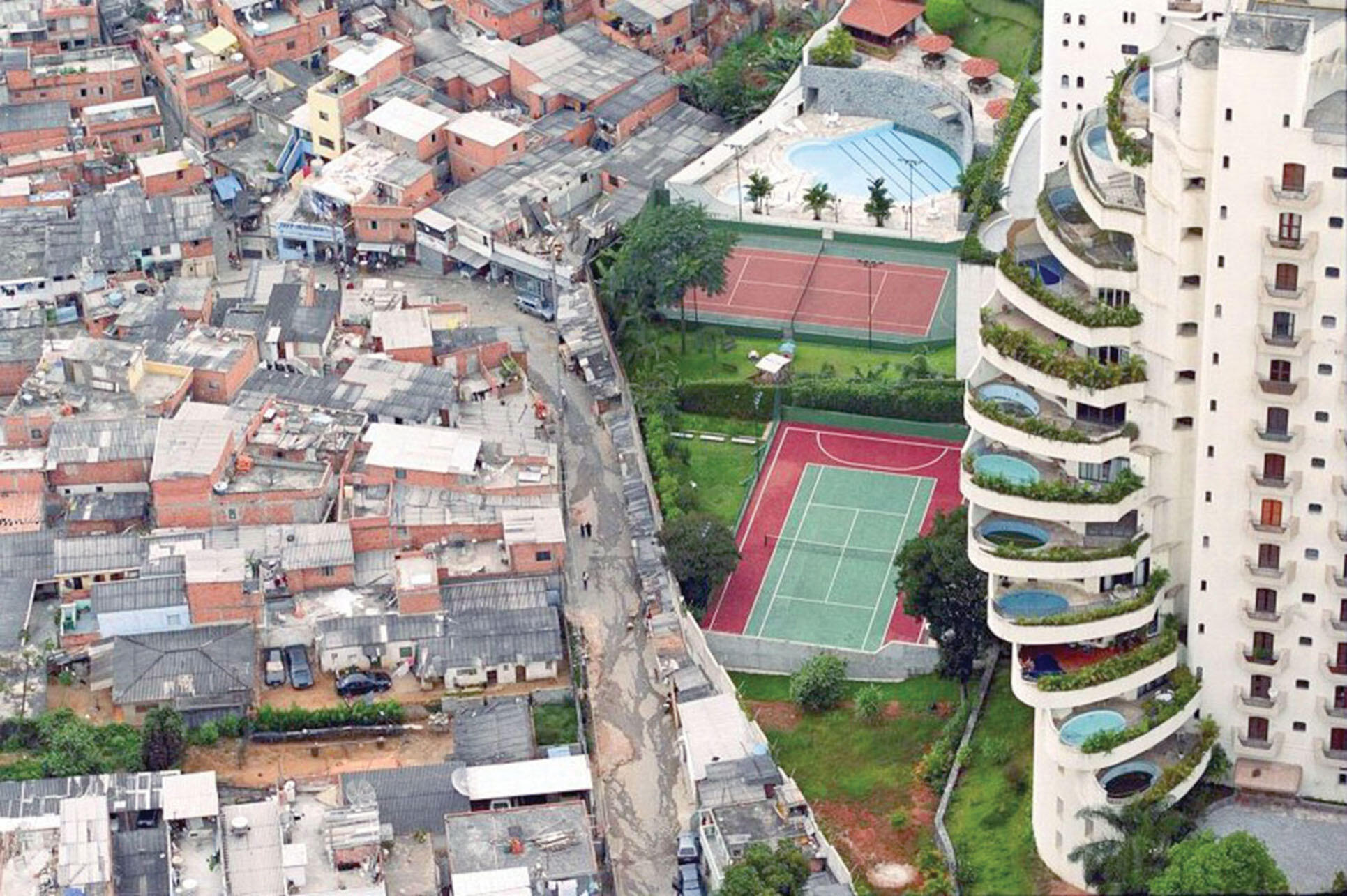 The Paraisópolis (Paradise City) favela is separated by a thin fence from an upscale apartment complex in São Paulo, Brazil. (Photo by Tuca Vieira.)