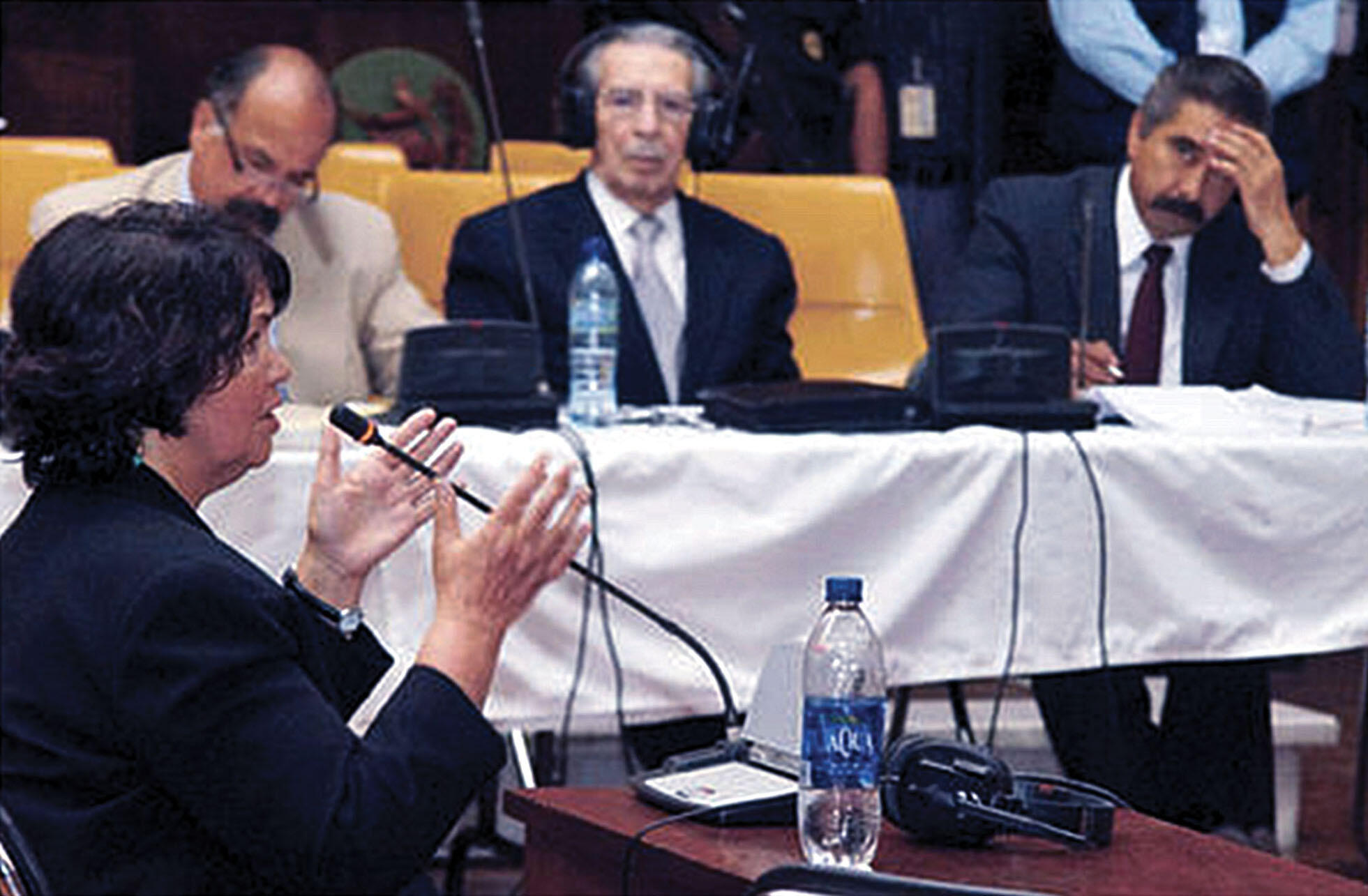Beatriz Manz testifies for the prosecution of Efraín Ríos Montt, who watches from a table in the background, April 2013. (Photo courtesy of Siglo21.)