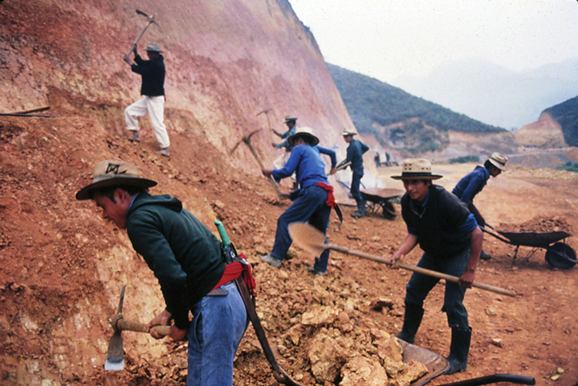 Men with simple picks and shovels are forced to move a hillside to build a road, Ixil region, Guatemala, March 1983. (Photo courtesy of Beatriz Manz.)
