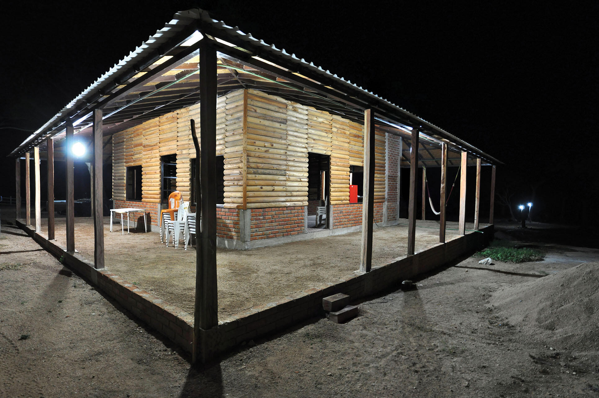Photo of a log cabin at night, a newly built private residence in an ejido in southern Mexico. (Photo by Eduardo Robles Pacheco.)