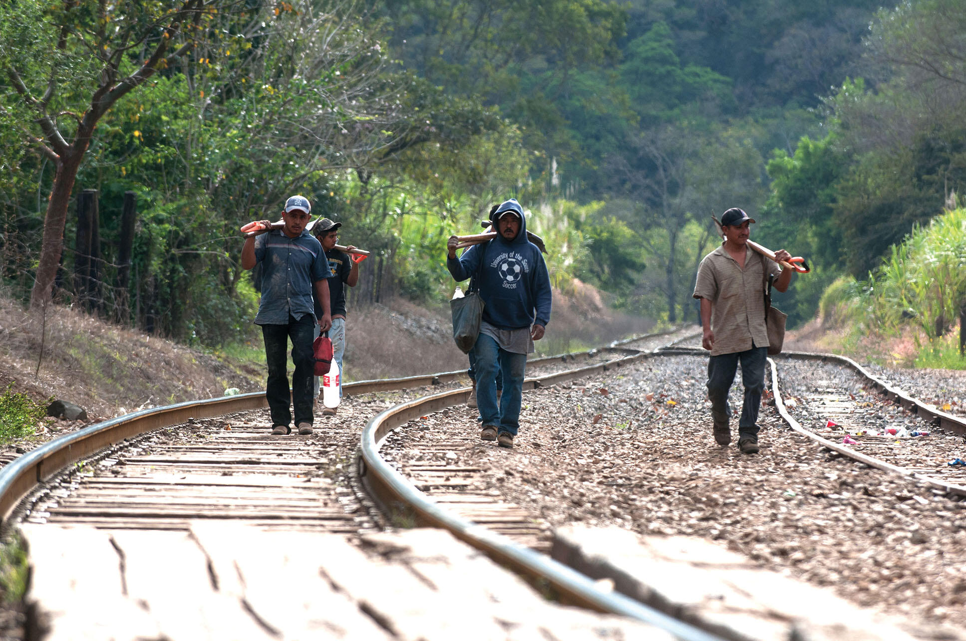 Ejidatarios walk down railroad tracks returning from a communal project. (Photo by Eneas De Troya.)