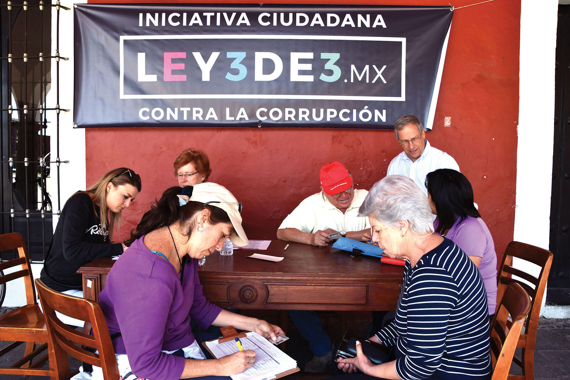 Mexicans line up at a table to sign a petition supporting the Ley 3de3 anti-corruption measure in Cholula. (Photo courtesy of Gobierno Cholula.)