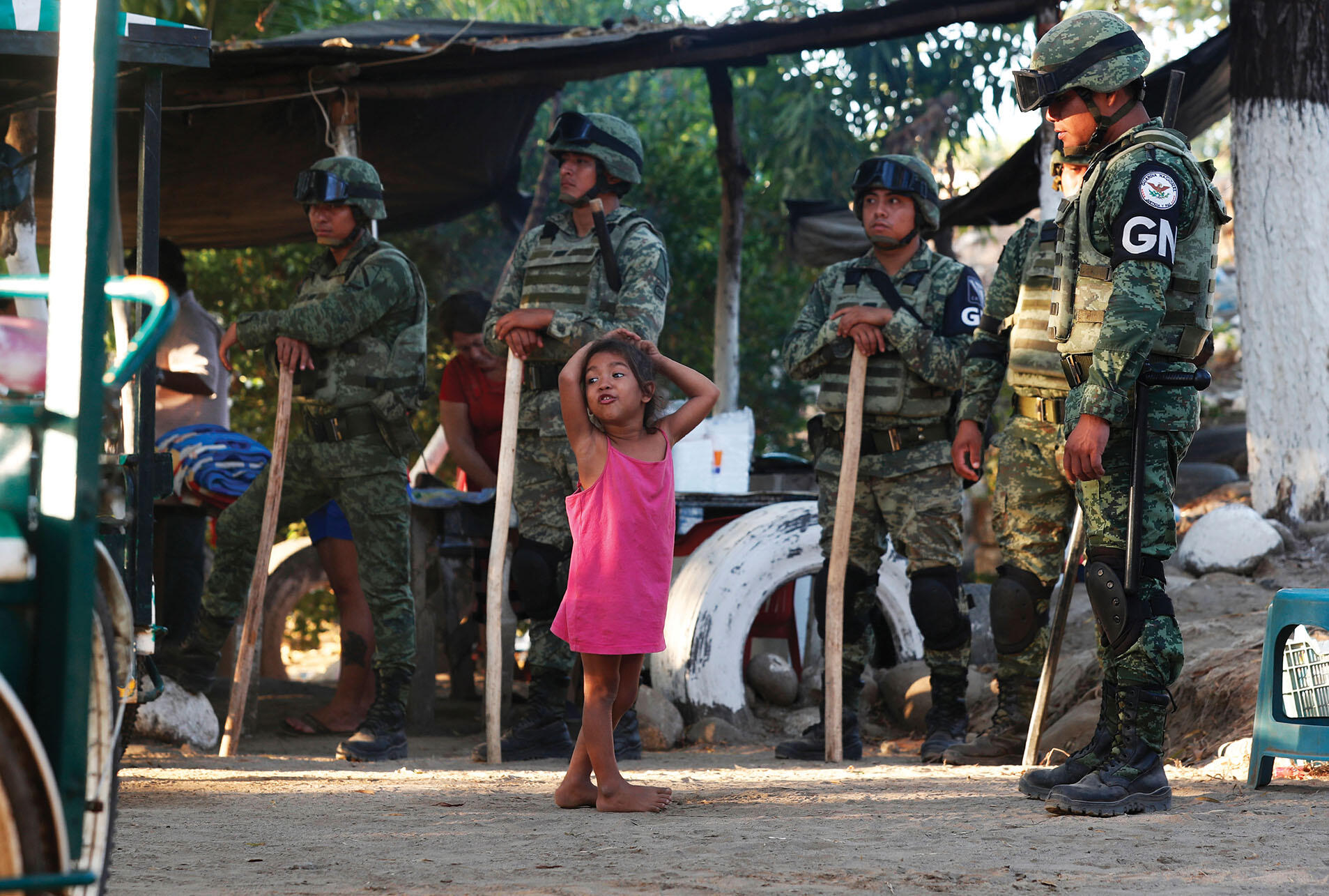 A Central American migrant child plays while Mexican National Guards detain her family on the border with Guatemala, January 2020. (Photo by Marco Ugarte/AP Photo.)